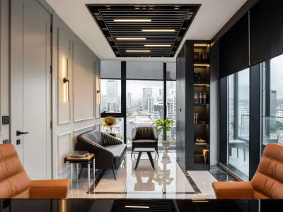 During the executive office decor process, we found it appropriate to include brown leather-upholstered seating elements to combine luxury and ergonomics. By centering the black lacquered executive desk in the spatial layout, we achieved an authoritative and timeless stance. We positioned the seating groups along an axis that facilitates a more fluid and intimate dialogue between the executive and their guests. We brought a contemporary vision to the interior through custom-produced linear pendant lighting elements applied on the ceiling plane. This lighting scheme we preferred reinforces the perception of depth and width of the volume while simultaneously delivering a homogeneous light distribution.