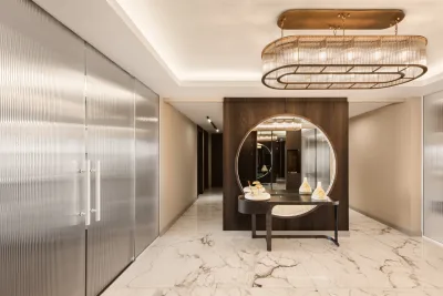 Reeded cam sürme kapılar arasında yuvarlak aynalı ahşap bölme ve mermer zeminli giriş holü